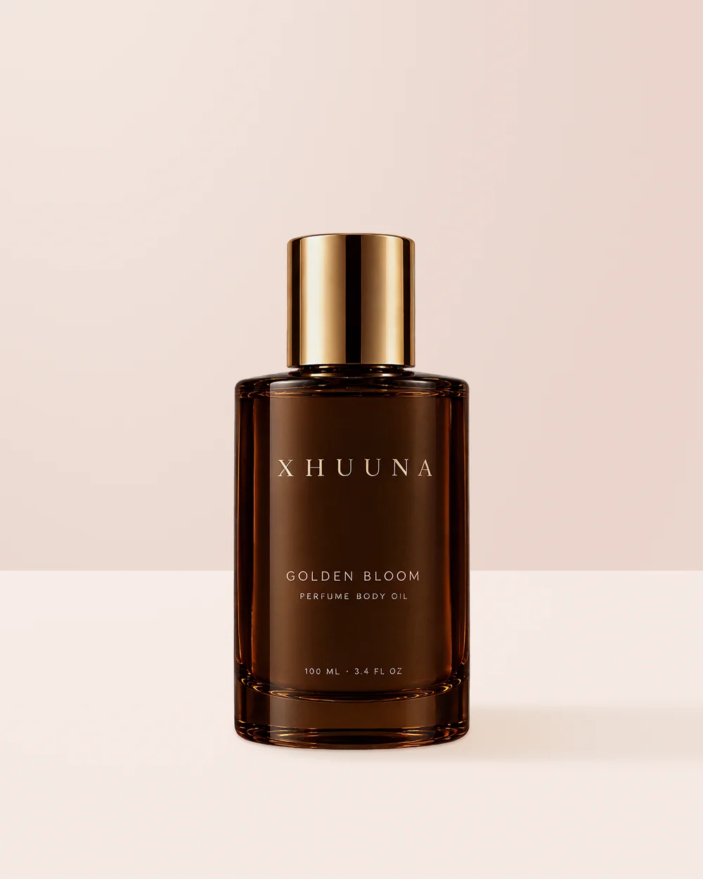 Xhuuna Golden Bloom perfume body oil in a dark amber bottle with a gold cap