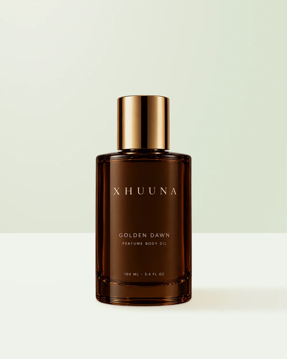 Xhuuna Golden Dawn perfume body oil in a dark amber bottle with a gold cap
